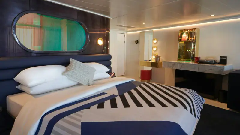 Virgin Voyages Brilliant Suite bedroom with a sofa and vanity