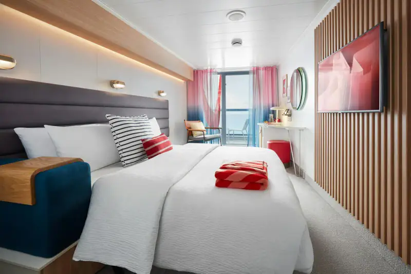 Virgin Voyages Sea Terrace category example with a bed, sofa, and vanity
