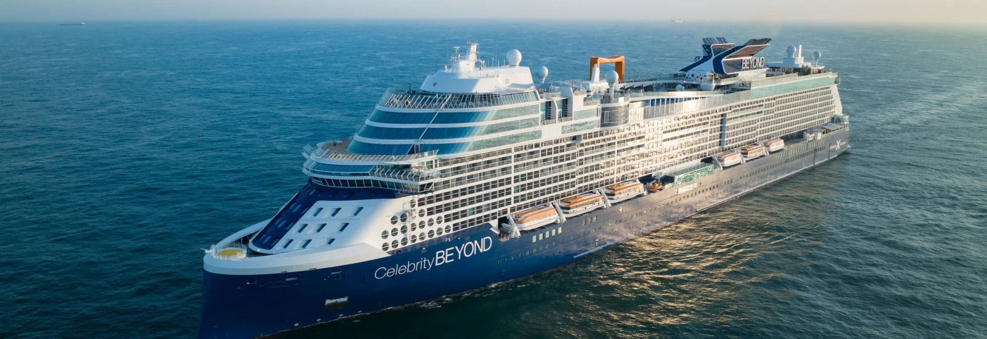 Celebrity Beyond sailing at sea in warm evening light