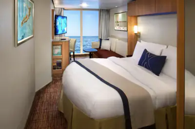 Renewed Panoramic Ocean View Stateroom with bed, lounge area, and ocean-facing windows