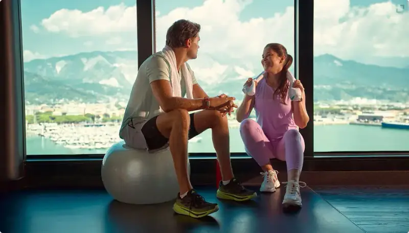 Two people exercising in Scarlet Lady's sea-view gym