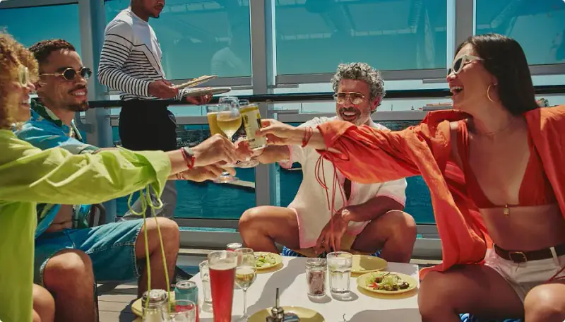 Sailors dining outdoors on Valiant Lady with the sea behind them