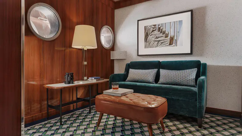 World Traveller Deluxe Horizon Suite sitting room with sofa and round windows