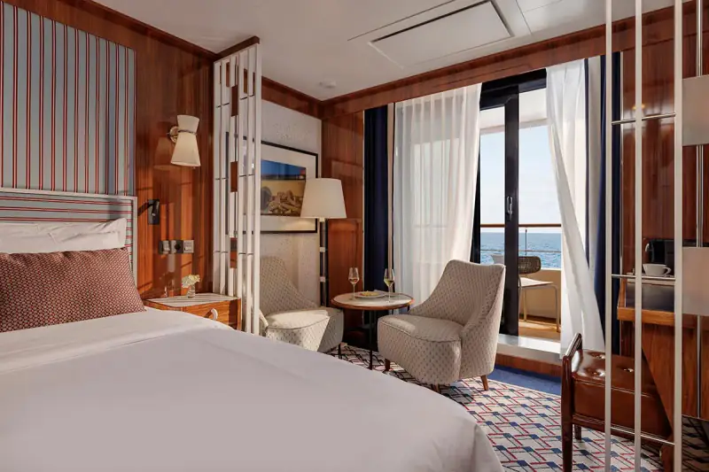 World Traveller Veranda Suite with bed, sitting area, and open veranda door