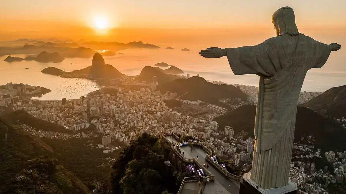 Christ the Redeemer overlooks Rio de Janeiro and its bays at sunrise.