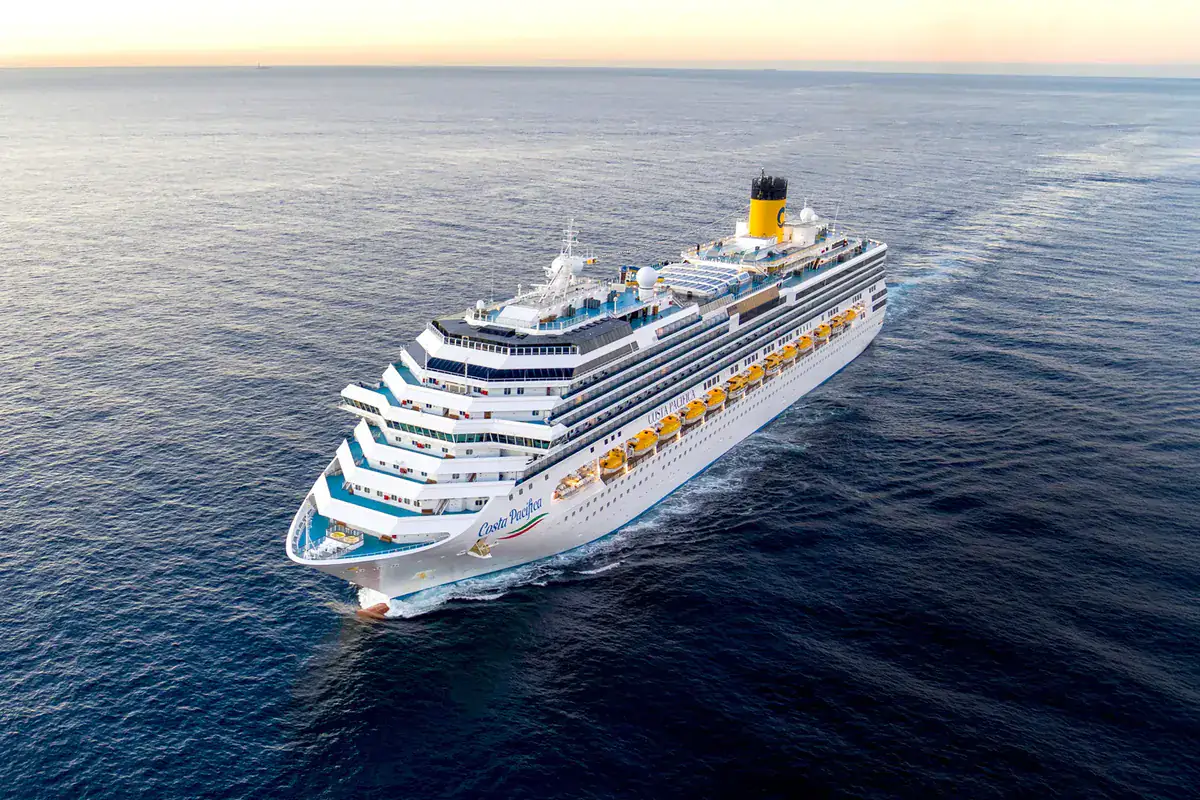 Costa Pacifica sails across calm open water in warm evening light.