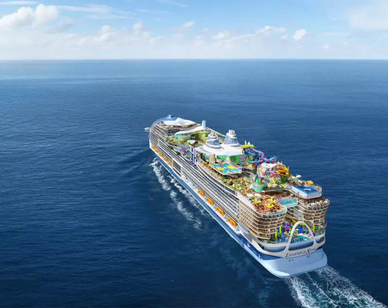 Legend of the Seas sails through deep-blue open water, viewed from above and behind.