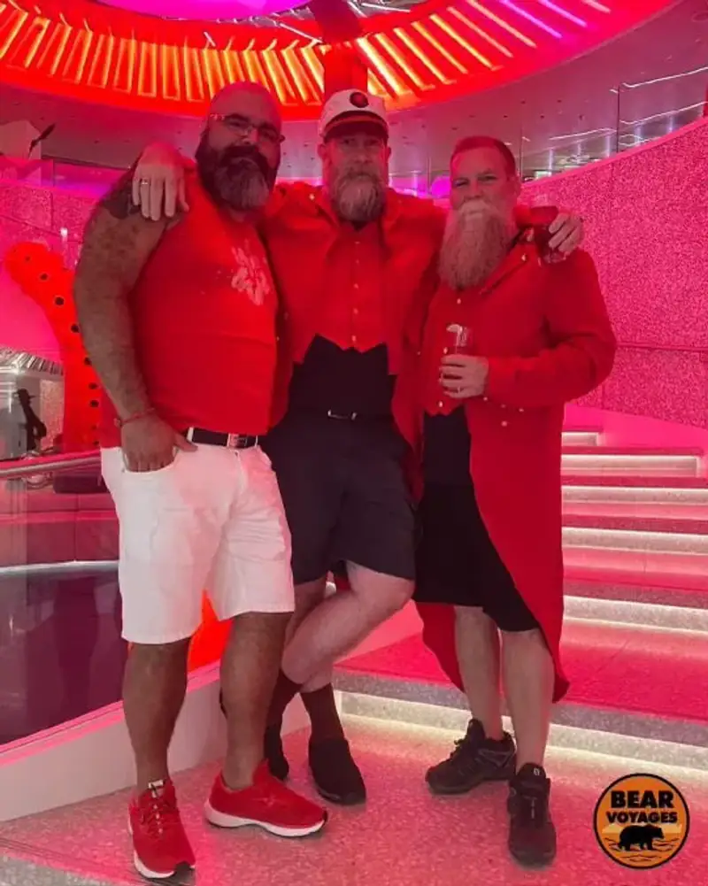 Four travelers pose on a red-lit cruise-ship staircase.