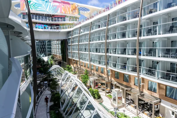 The glass-roofed central promenade inside a large cruise ship.
