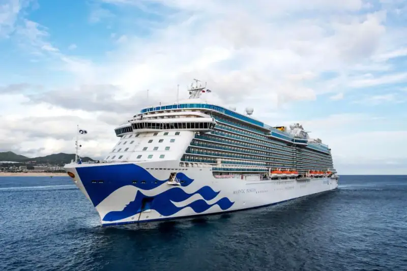 A Princess cruise ship sails through calm blue water.