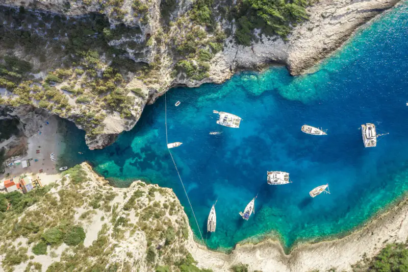 Aerial view of a turquoise Adriatic cove and rocky coastline.