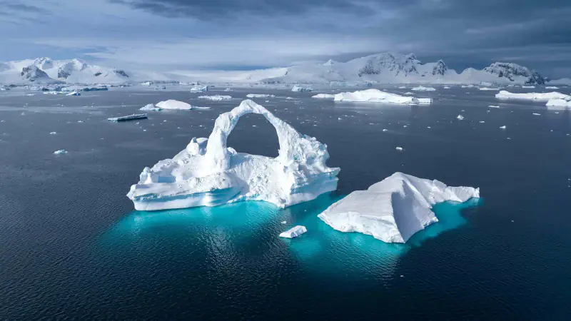 An iceberg floats in dark Antarctic water.