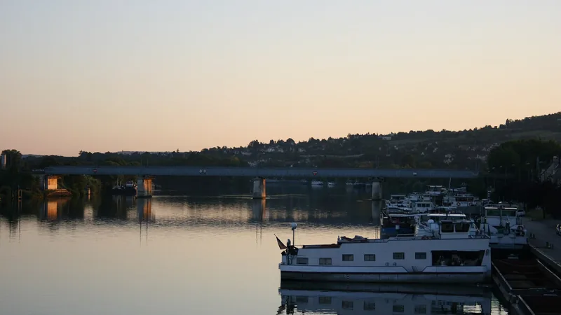Moored river vessels along the Seine waterfront in Conflans-Sainte-Honorine at dusk