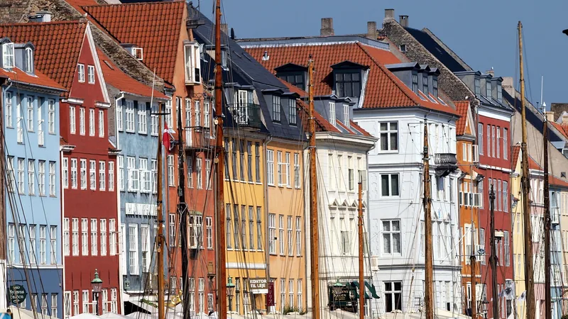 Colorful Nyhavn waterfront buildings, boats, and cafés in Copenhagen