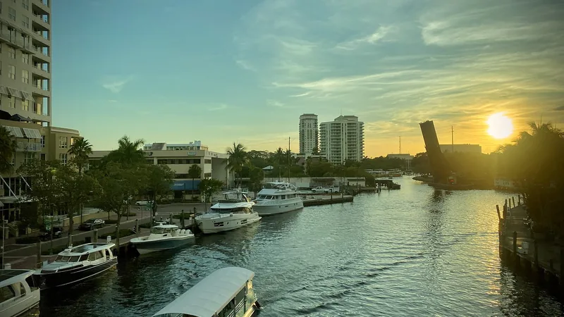 Boats on a Fort Lauderdale waterway beneath a glowing sunset
