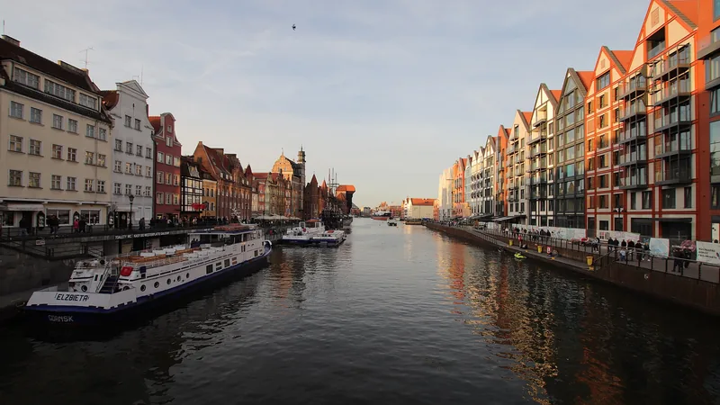 Historic waterfront buildings and sightseeing boats along Gdańsk’s Motława in 2019; not a cruise terminal photograph
