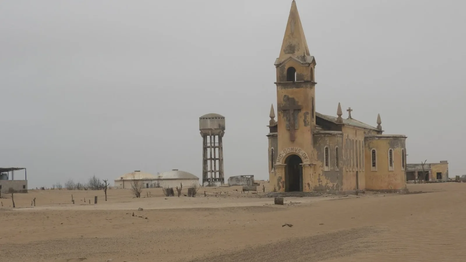 An abandoned chapel and water tower in the sandy settlement on Ilha dos Tigres, photographed in 2020