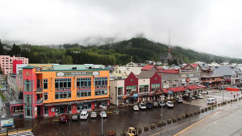 Colorful downtown Ketchikan waterfront beneath misty forest