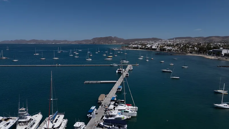 Aerial view of La Paz's malecón, marina, blue bay, and desert mountains