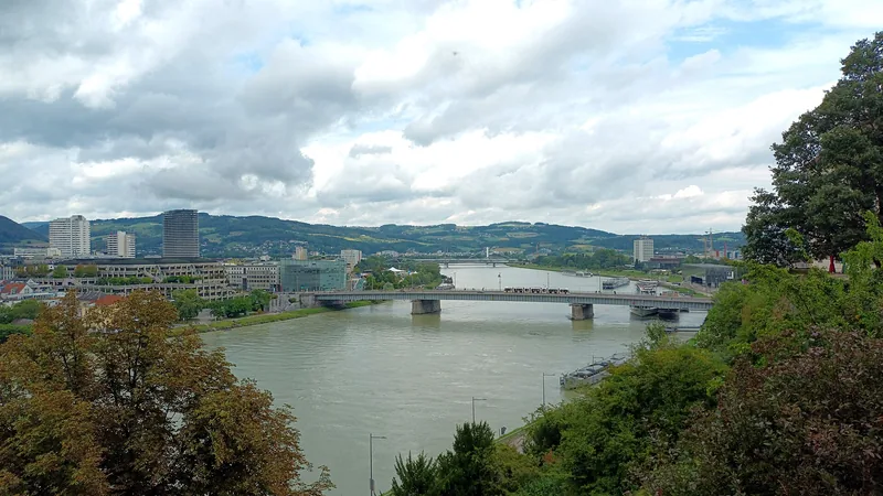 The Danube running through Linz beneath a bright Austrian sky