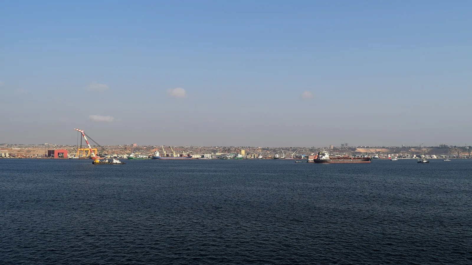 Cargo ships and harbor cranes across Luanda Bay in a historical 2015 view, not a current cruise berth map