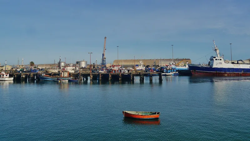 Fishing vessels and harbor buildings across the water in Lüderitz, photographed in 2017