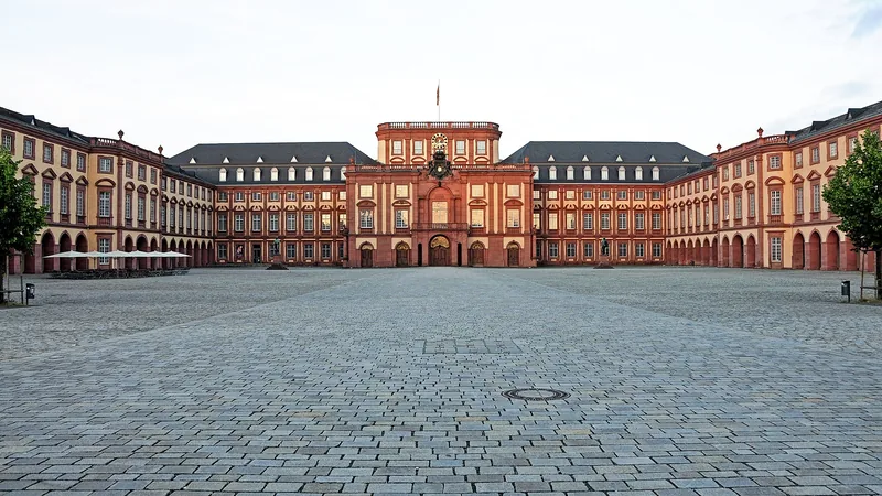 Red and cream façade of Mannheim Palace across the courtyard
