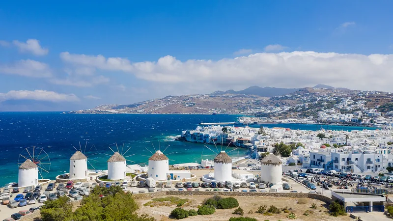 Mykonos windmills, whitewashed town, and blue Aegean Sea