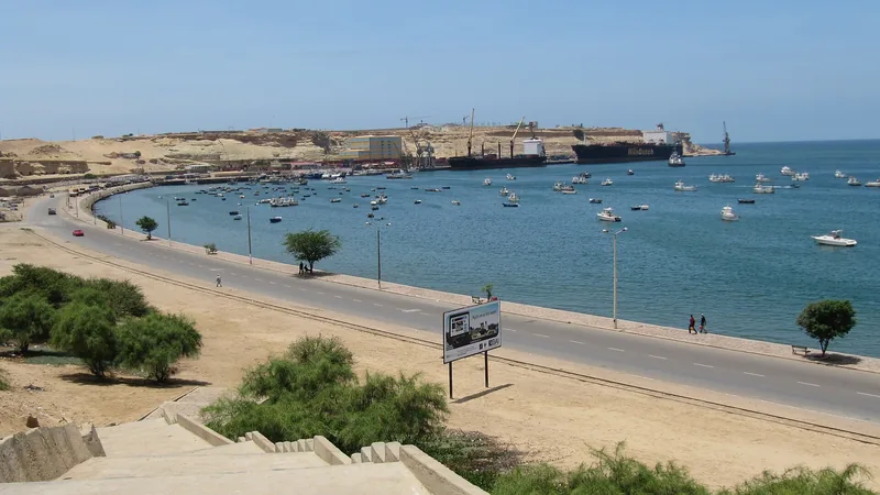 Namibe waterfront road, small boats and commercial harbor in a historical view of Moçâmedes