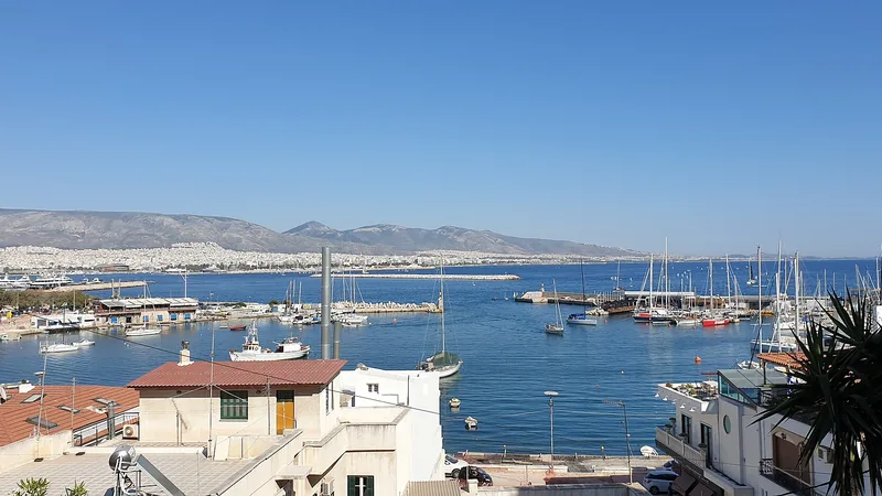 Mikrolimano harbor in Piraeus with boats, waterfront homes, and hills