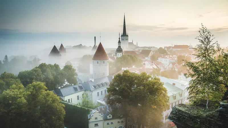 Tallinn Old Town towers and roofs in sunrise mist, viewed from Patkul in September 2018