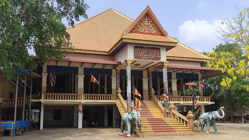 The monastery facade and stairway between elephant statues at Wat Hanchey